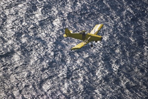Small airplane ascending over water. Photographer: fotog