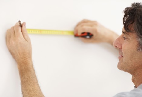 Carpenter measuring wall. Photographer: momentimages