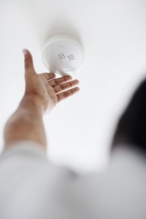 Testing battery in smoke detector. Photographer: momentimages