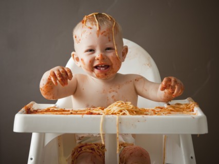 Baby covered in spaghetti. Photographer: Mike Kemp