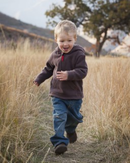 Boy running in meadow. Photographer: Mike Kemp