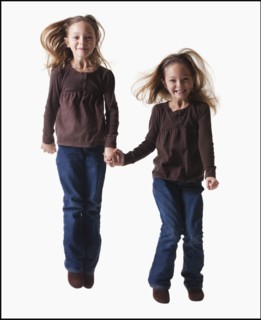 Identical twins jumping. Photographer: Mike Kemp