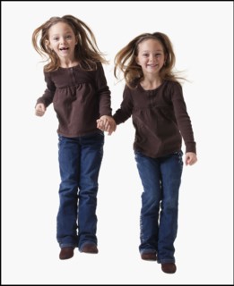Identical twins jumping. Photographer: Mike Kemp