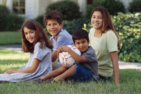 Siblings sitting on the lawn. Photographer: Rob Lewine