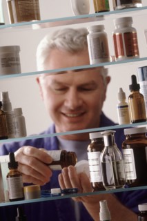 Man in front of medicine cabinet. Photographer: Rob Lewine