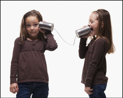 Girls playing with tin can phones. Photographer: Mike Kemp