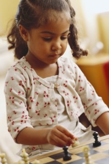 Young girl playing chess. Photographer: Rob Lewine