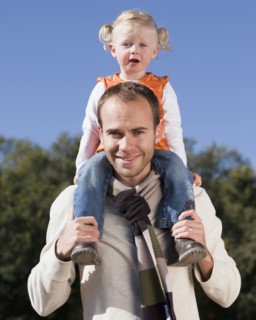 Father holding daughter on his shoulders. Photographer: Mike Kemp
