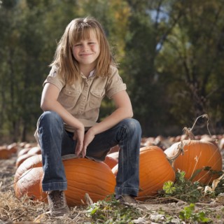 Girl in pumpkin patch. Photographer: Mike Kemp