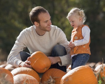 Father and daughter in pumpkin patch. Photographer: Mike Kemp