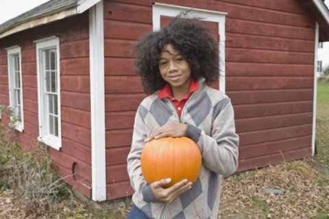 Woman holding a pumpkin. Photographer: Pauline St.Denis