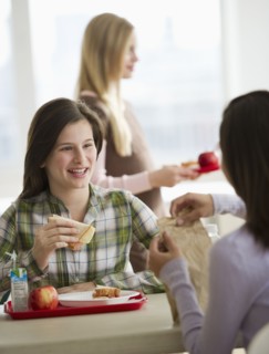 Friends eating in cafeteria.