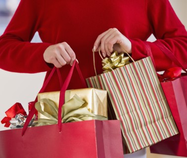 Woman holding bags of gifts.