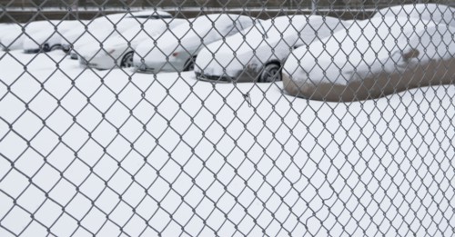 Parking lot behind chain link fence. Photographer: fotog