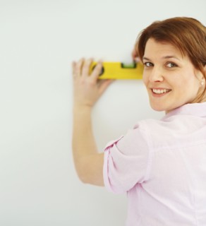 Woman using a level. Photographer: momentimages