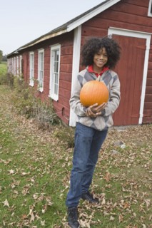 Woman holding a pumpkin. Photographer: Pauline St.Denis