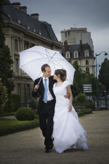 Bride and groom walking in the rain. Photographer: Mike Kemp