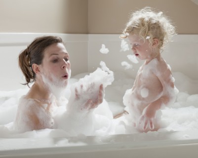 Mother and child having bubble bath. Photographer: Mike Kemp