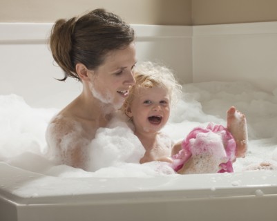 Mother and child having bubble bath. Photographer: Mike Kemp