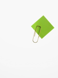 Paper clip and green paper. Photographer: David Arky