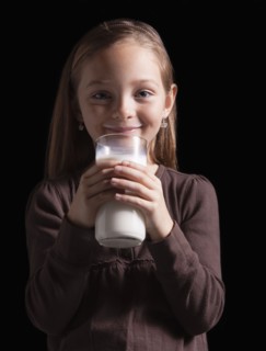 Young girl drinking glass of milk. Photographer: Mike Kemp