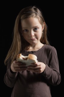 Young girl eating a sandwich. Photographer: Mike Kemp