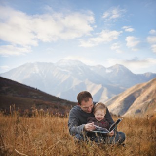 Father and son reading outdoors. Photographer: Mike Kemp