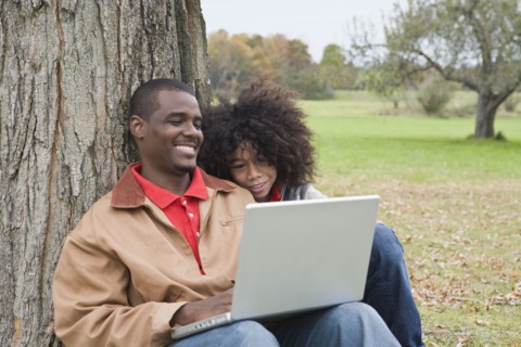 Couple looking at laptop outside. Photographer: Pauline St.Denis