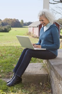Woman working on laptop on porch. Photographer: Pauline St.Denis