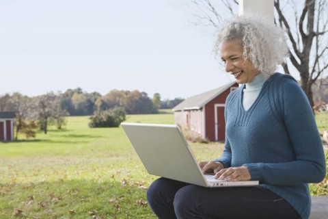 Woman working on laptop on porch. Photographer: Pauline St.Denis