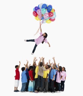 Girl floating away with balloons. Photographer: momentimages