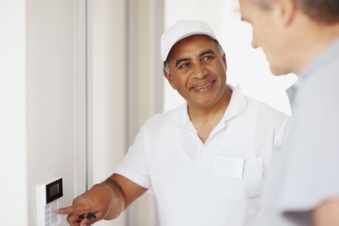 Man demonstrating how alarm system works. Photographer: momentimages