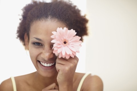 Woman holding flower. Photographer: momentimages