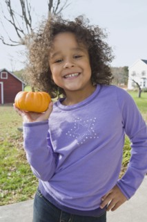 Young girl holding pumpkin. Photographer: Pauline St.Denis