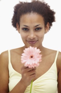 Woman holding flower. Photographer: momentimages