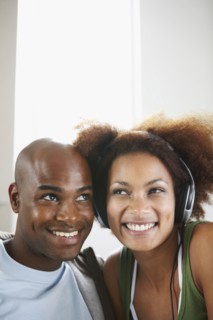 Woman listening to music on headphones. Photographer: momentimages