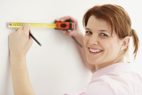Woman using measuring tape. Photographer: momentimages