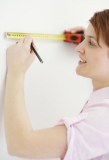 Woman using measuring tape. Photographer: momentimages