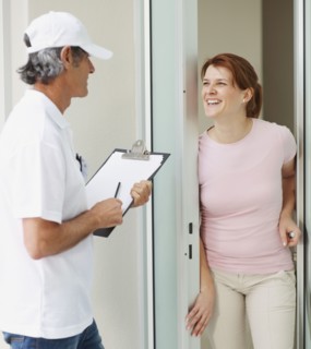 Woman talking to man at the door. Photographer: momentimages