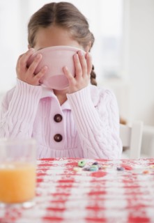 Young girl eating. Photographer: Jamie Grill
