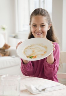 Young girl holding plate. Photographer: Jamie Grill