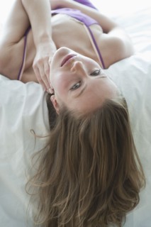 Woman lying on bed.