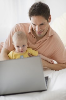 Father and baby looking at laptop.