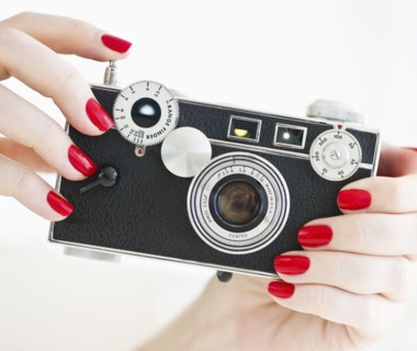 Woman holding antique camera.
