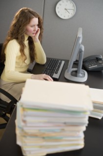 Overworked woman in cubicle.