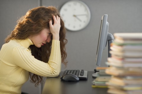 Overworked woman in cubicle.