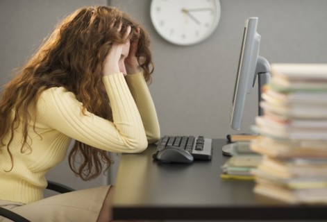 Overworked woman in cubicle.
