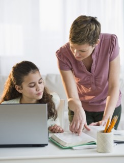 Mother helping daughter with her homework.