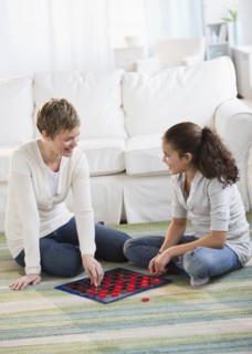 Mother and daughter playing checkers.