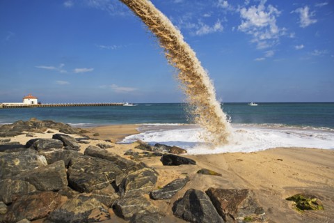 Pipe spraying sand on beach. Photographe : fotog